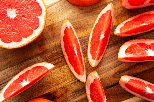 Organic Red Ruby Grapefruit on a Wooden Board, top view. Overhead, from above, flat lay.