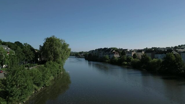 Drone flying over Mayenne river at Laval in France. Aerial forward ascending. Sky for copy space