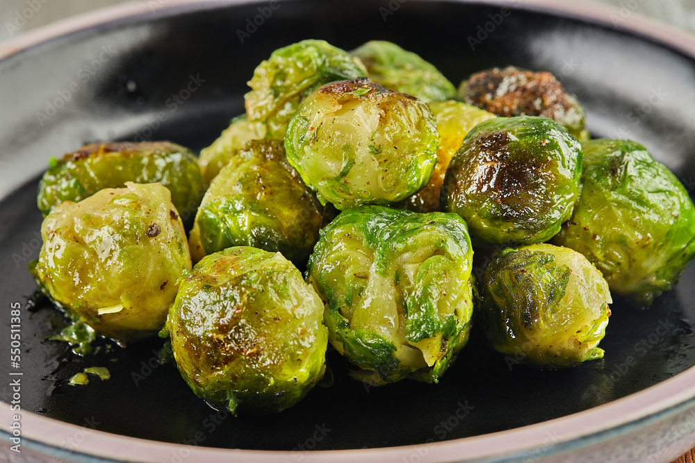 Canvas Prints French recipe Brussels sprouts on black plate on wooden background