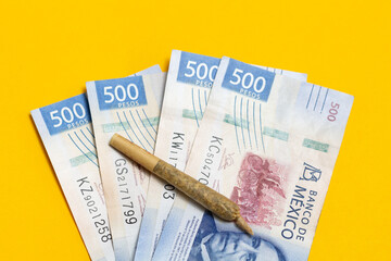 Marijuana cigarette on Mexican bills of 500 pesos. concept of economy and drug legalization