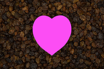 Obraz premium Vibrant pink love heart middle of fresh shiny brown Australian sun-ripened sultanas filling the frame 
