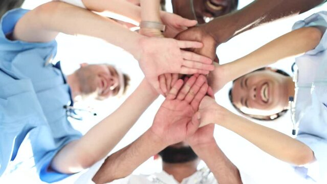 Low Angle View Of Doctor Stacking Hands Together In Hospital