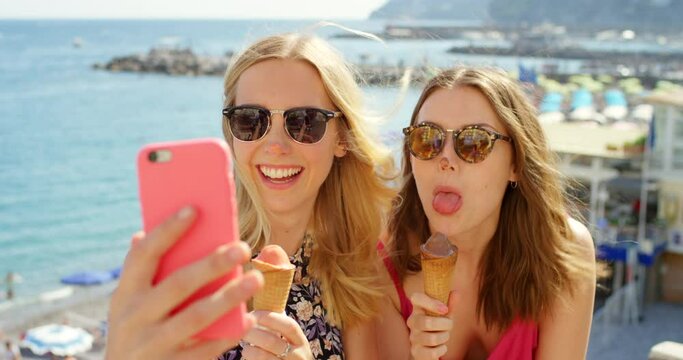 Friends, phone and selfie with ice cream, happy and humour while taking picture on travel, trip and summer vacation. Women, silly and social media influencer pose with icecream for blog in Miami
