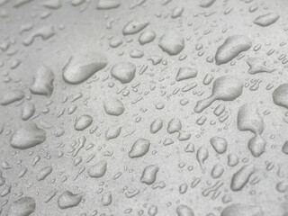 water drops at metallic surface reflecting water and light. waterdrops. raindrops
