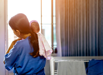 Asian woman holding a newborn baby while sleep in her arms. Mother and baby stay isolation at hospital or home for self quarantine due to epidemic of COVID 19