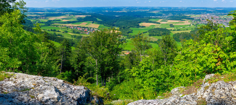 Panorama der nördlichen schwäbischen Alb mit Feldern und Dörfern und Felsen im Vordergrund