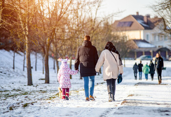 Mother father and daughter walking in the winter Park