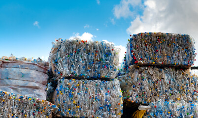Old plastic bottles that have been used are squeezed and bundled together to prepare for recycling. - obrazy, fototapety, plakaty