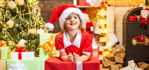 Obraz na płótnie Canvas Cute little kids celebrating Christmas. Christmas kids celebration holiday. Happy cute child in Santa hat with present have a Christmas.