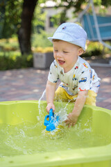 Boy playing with water in the yard in summer