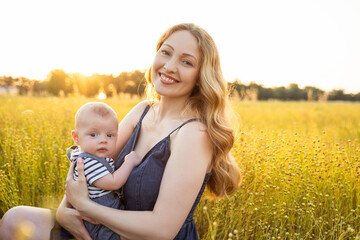 Mom holding a baby in her arms at sunset