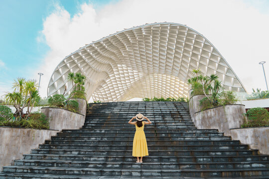 Woman Traveler with yellow dress visiting in Da Nang city. Tourist sightseeing the city building. Landmark and popular for tourist attraction. Vietnam and Southeast Asia travel concept
