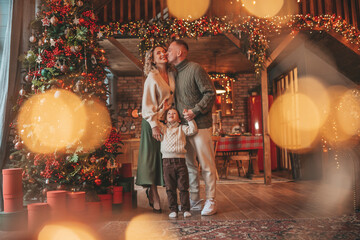 Candid authentic happy family during wintertime together enjoying holidays at wooden lodge at Xmas