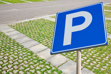 Parking areas with road sign and grey concrete permeable to rain flooring blocks assembled on a...