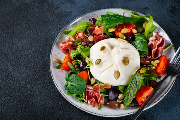 Salad with Tomatoes and Burrata cheese with basil and hamon. Mozzarella cheese with salad