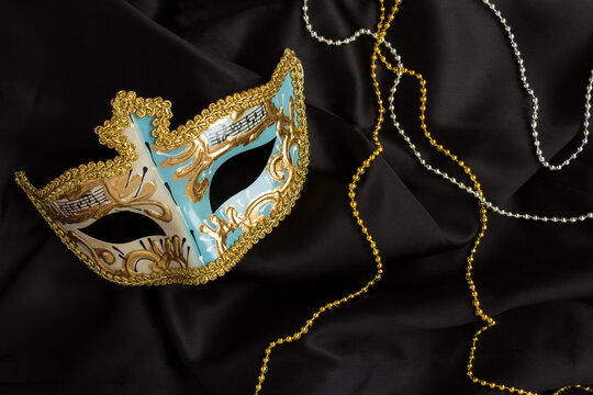 Christmas carnival mask on the on the black textile background. Top view. Close-up.