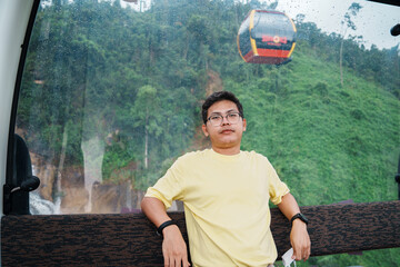  man sitting in Cable car with Ba Na Hills Mountain in the fog. Landmark and popular. Da Nang,...