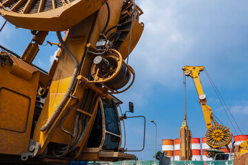 Fototapeta premium Low angle view of Earth drilling crawler crane with hydraulic diaphragm wall equipment working on highway in road construction site for elevated road construction project