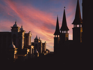 Obraz premium View of several black silhouettes of historic palace towers against a sunset orange sky and a sunbeam