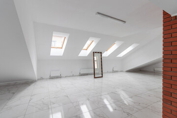 Spacious empty hollow attic with a tiled floor and a large mirror