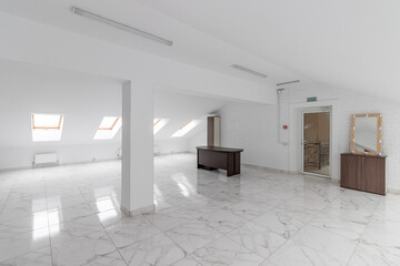 Spacious empty hollow attic with a tiled floor and a large mirror