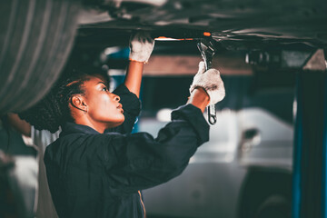 Garage women worker mechanic team working car auto service fix replace  under car lift hoist - Powered by Adobe