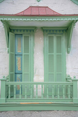 San Antonio, Texas- Green shutter style balcony window doors with wooden railings