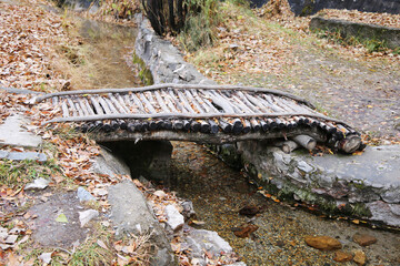 Small wooden bridge over a stream in autumn