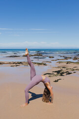 wheel pose yoga on the beach