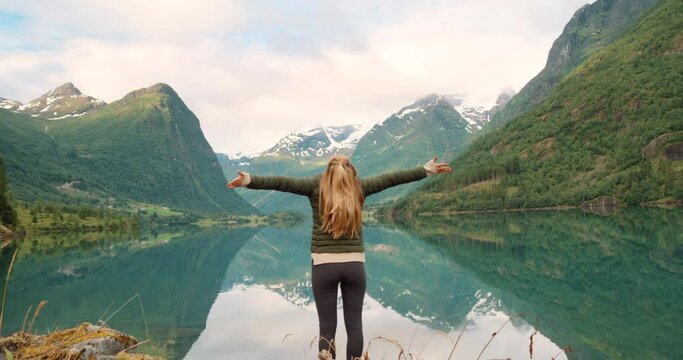 Nature, freedom and woman at lake with mountain view, a holiday adventure hiking in Switzerland. Travel, wellness and fresh air and water in snow capped mountains, achievement of mental health goals
