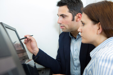 closeup of a man and woman pointing to screen