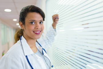 portrait of nurse stood by frosted glass window in hospital