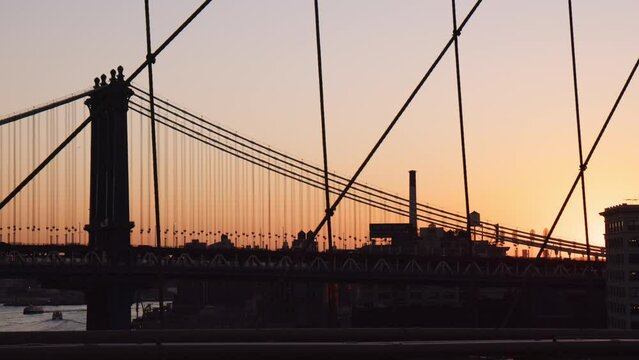 Iconic silhouette of Manhattan bridge, view from Brooklyn bridge at sunrise, handheld