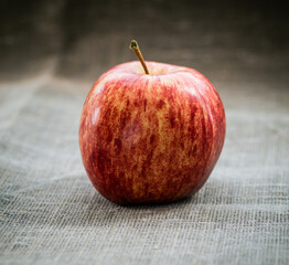 Fresh red apple on sackcloth. Selective focus.