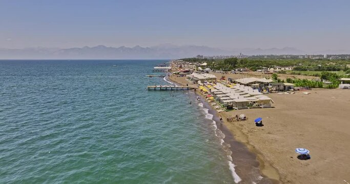 Antalya Turkey Aerial v28 low flyover long stretched lara beach capturing coastal activities and private luxury beach club with mountain silhouette on the skyline - Shot with Mavic 3 Cine - July 2022