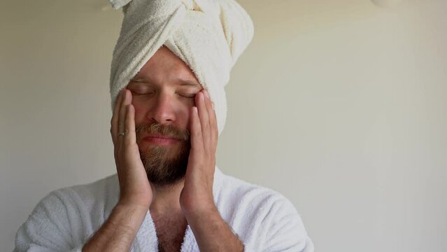 Middle-Aged Caucasian Bearded Man Wear White Bathrobe And Towel On Head. Morning Routine Personal Hygiene. Blank For Advertisement, Mock-Up, Template