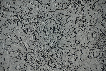 Closeup of dark gray wall with stucco worm finish