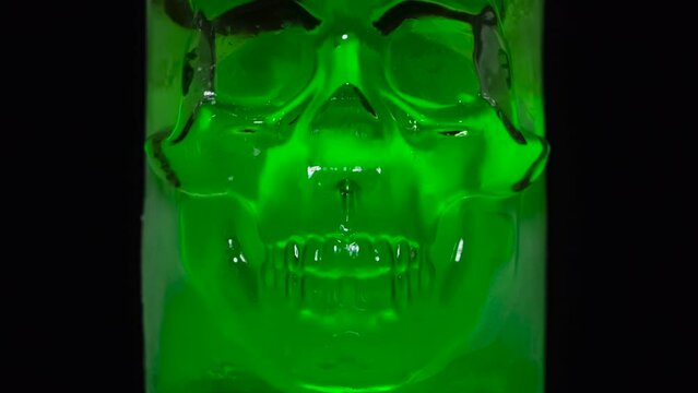 Rapid Melting of Ice Skull. Timelapse. Ice skull covered with frost quickly melts and glistening disappears in the dark