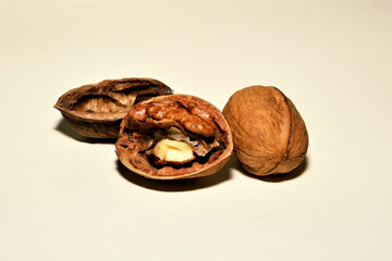 Open walnut rods on a white background next to a whole walnut