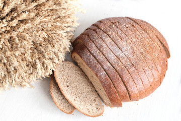 Sliced rye bread. Ears of wheat, sheaf. Bakery concept, rich harvest. White background.