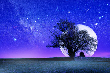 Lonely grave with oak tree under starry and Moonlit night.