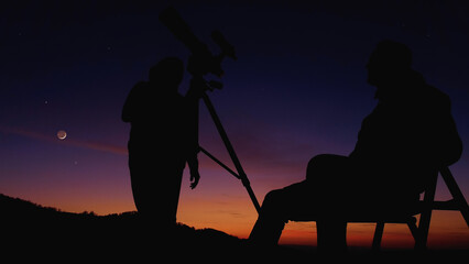 Men with astronomy telescope looking at the night sky, stars, planets, Moon and shooting stars.
