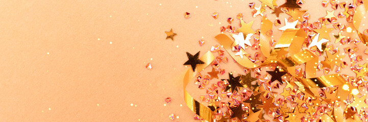 Golden ribbons, shine stars and crystals confetti. Festive concept with copy space. Selective focus.