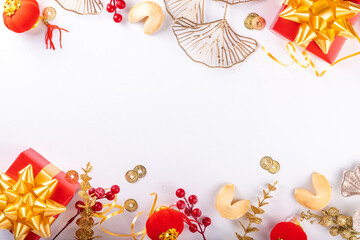 Chinese New Year on white background. Lunar New Year greeting card with traditional festival decoration - ginkgo biloba, golden twigs, gift boxes, red berries, gift envelopes, coins, chinese lanterns