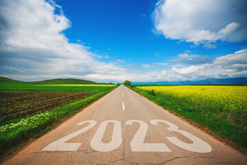 Travel, lifestyle and agriculture concept for new year 2023. Driving on an empty asphalt road at...