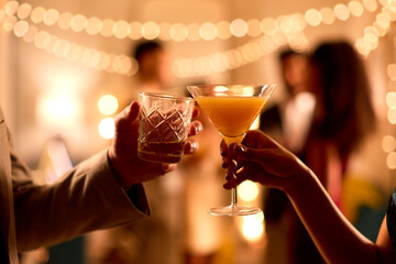 Close Up Of Couple At Party Making A Toast With Drinks Together
