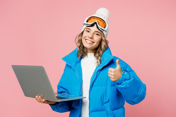 Snowboarder IT woman in blue suit goggles mask hat ski padded jacket work use laptop pc computer show thumb up isolated on plain pink background Winter extreme sport hobby weekend trip relax concept