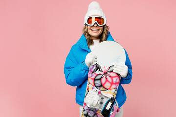 Snowboarder excited woman wear blue suit goggles mask hat ski padded jacket hold snowboard behind neck isolated on plain pastel pink background. Winter extreme sport hobby weekend trip relax concept. - Powered by Adobe