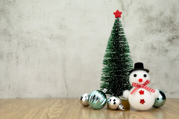 Christmas tree with decoration on wooden table. Mini Christmas tree with Snowman.