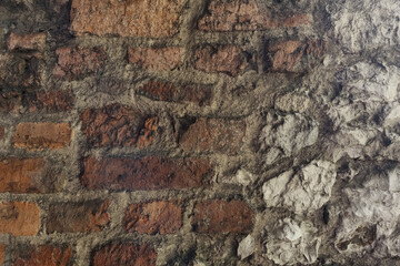 Fragment of the old wall of the building, brick background and concrete.